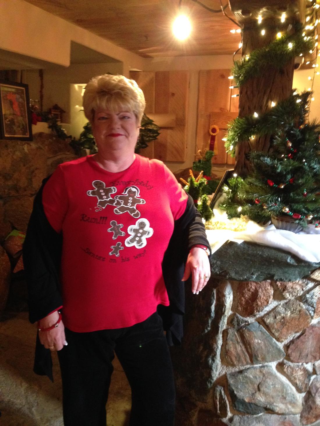 A member in her Christmas red by the tree
