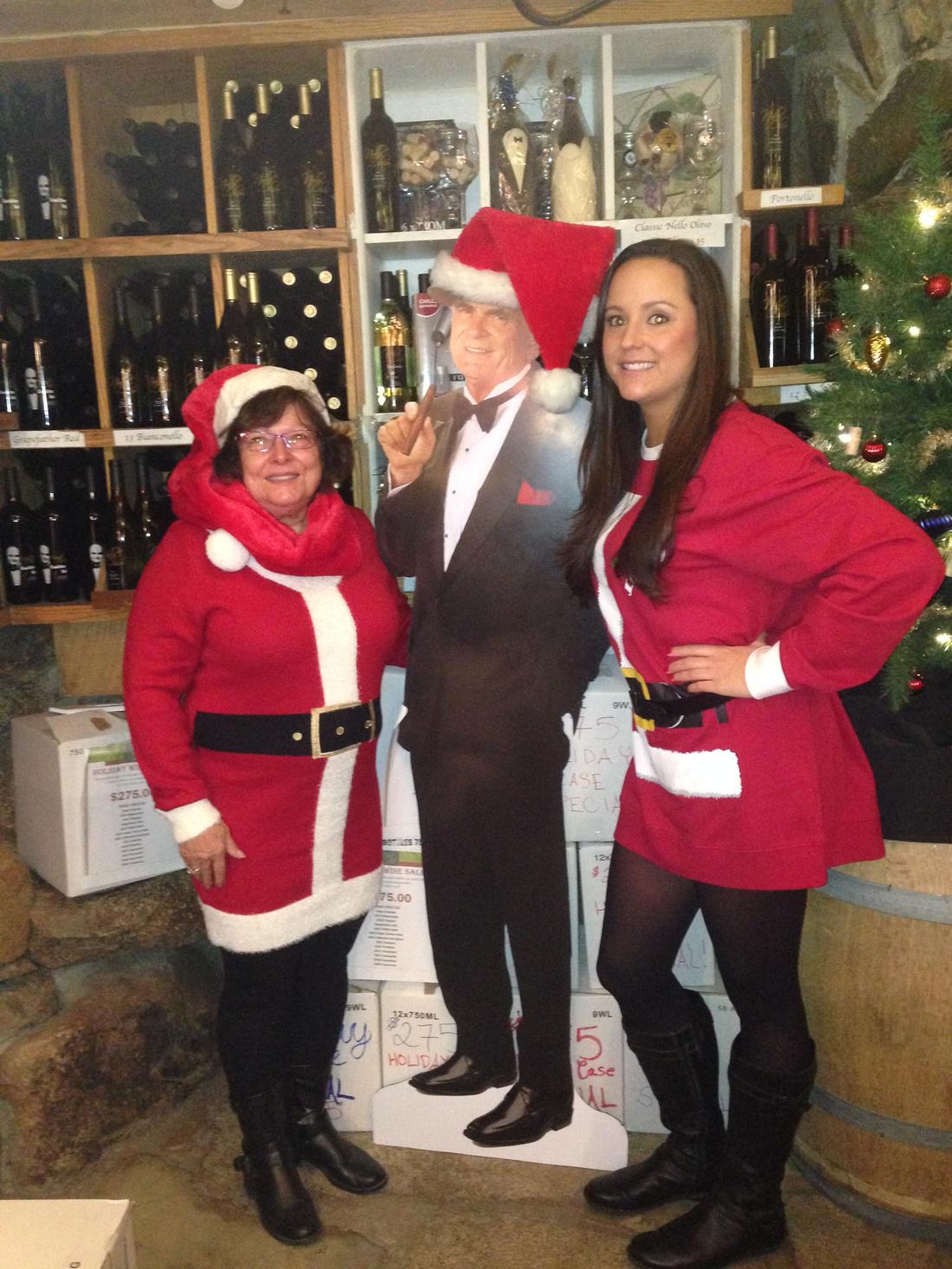 Two members in Santa suits flanking the Sinatra cutout